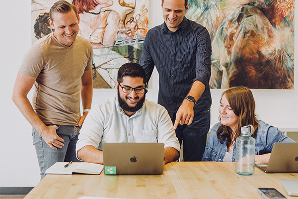 Four people reviewing a document and smiling